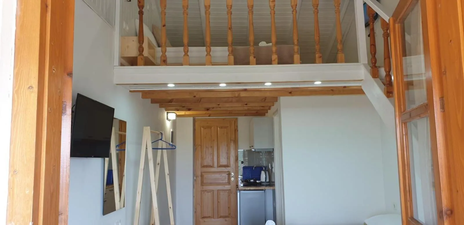 The loft gallery above the kitchenette and a pine door