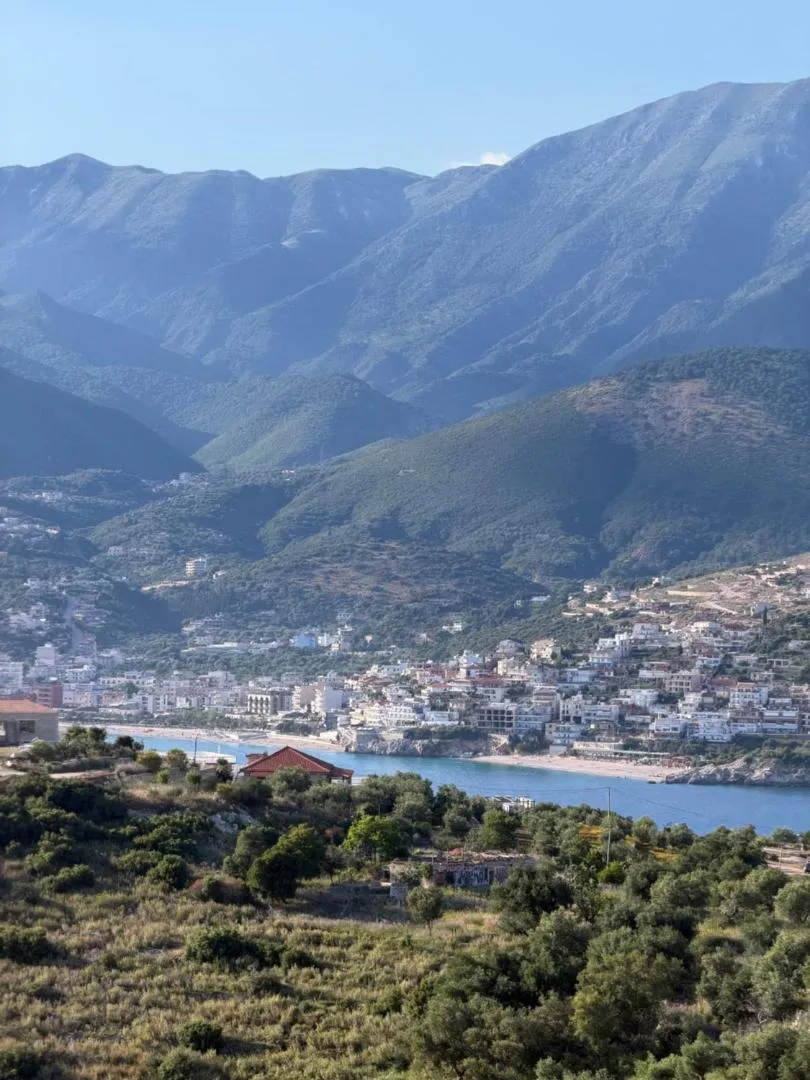 Himarë town on its bay seen from the hillside above, mountains behind