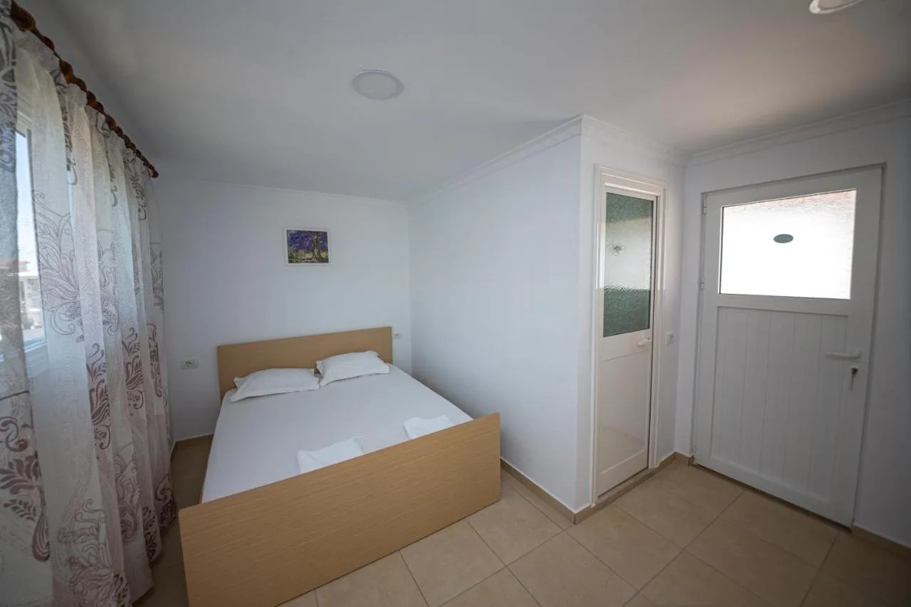 The double bed in the studio, with the bathroom door and the entrance door beside it