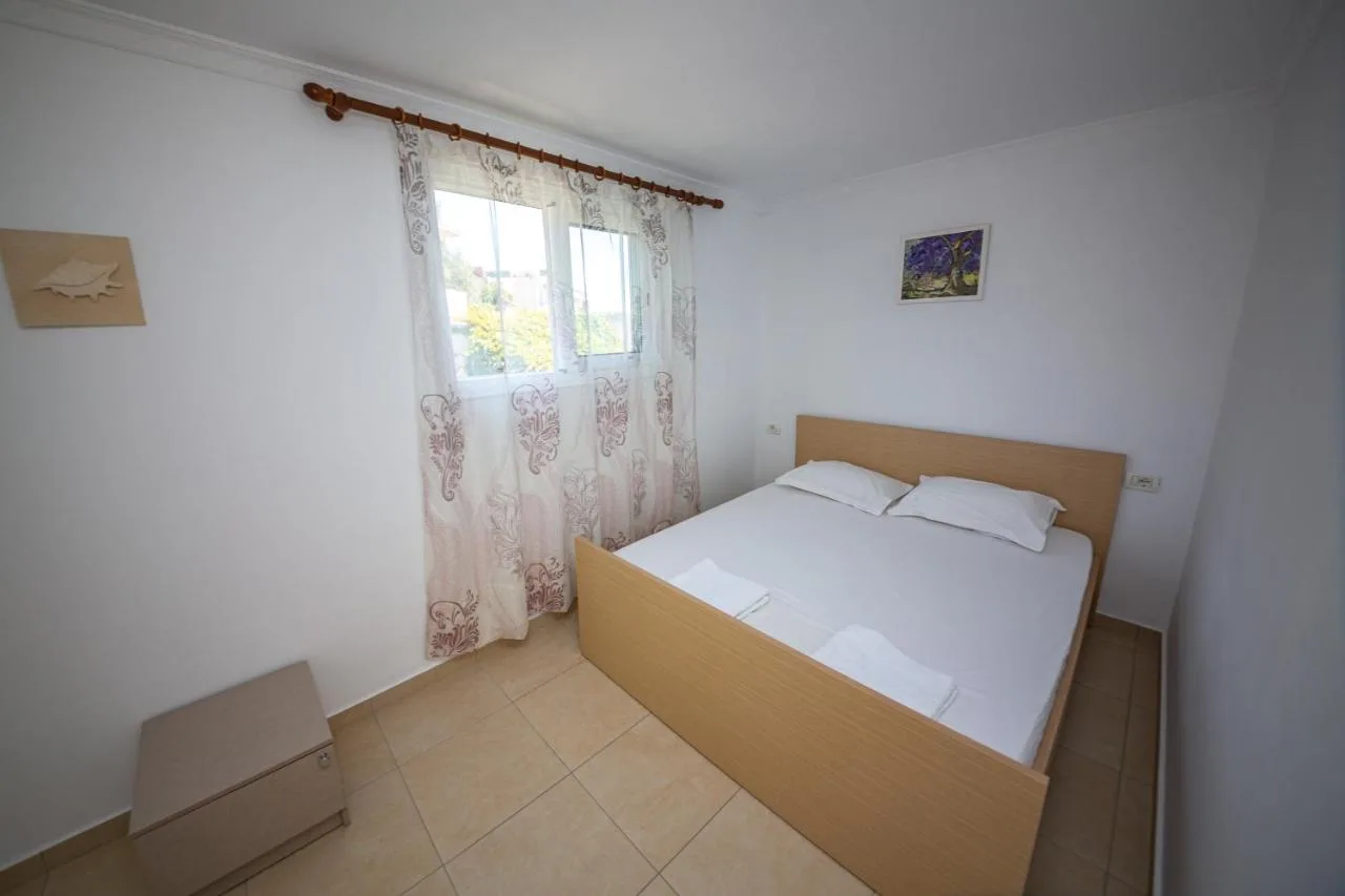 A double bed under a window with patterned curtains in the double studio