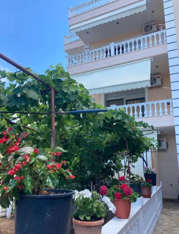 Pots of red geraniums and a vine at the foot of the balconies at Himara Apartments