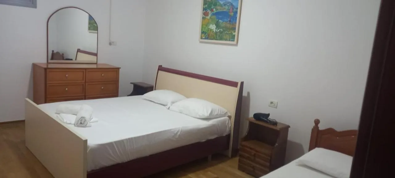 The bedroom with a double bed, a dresser and mirror, and a single bed beside it