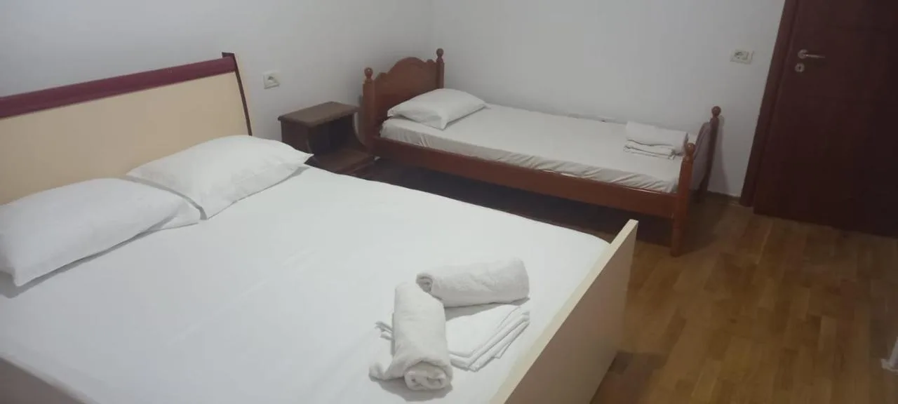 A double bed and a single bed with folded towels in the ground-floor apartment