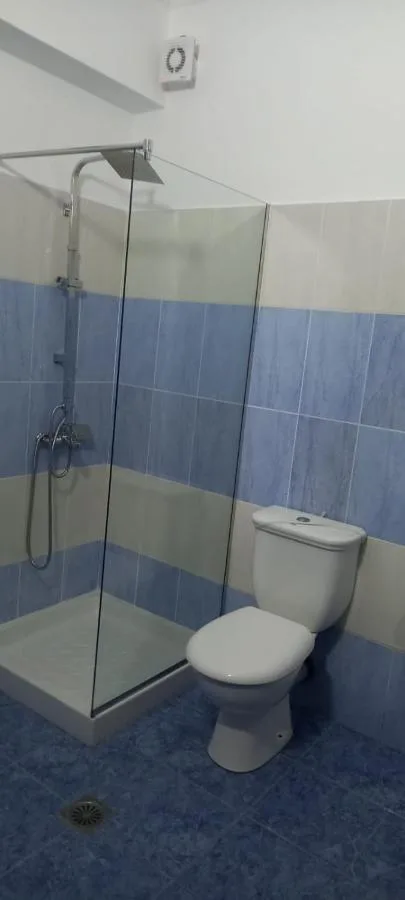 The ground-floor shower room with blue tiles and a glass cubicle
