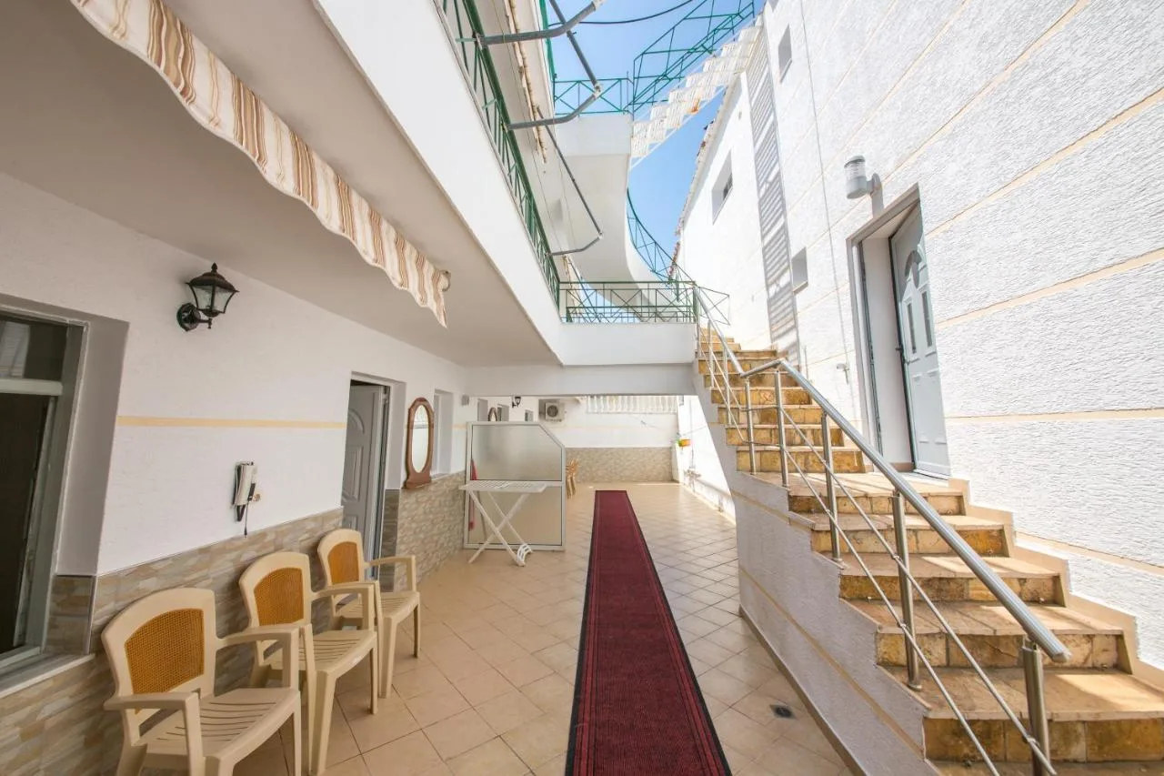 The studios' courtyard with an awning, chairs and the staircase up to the floors above