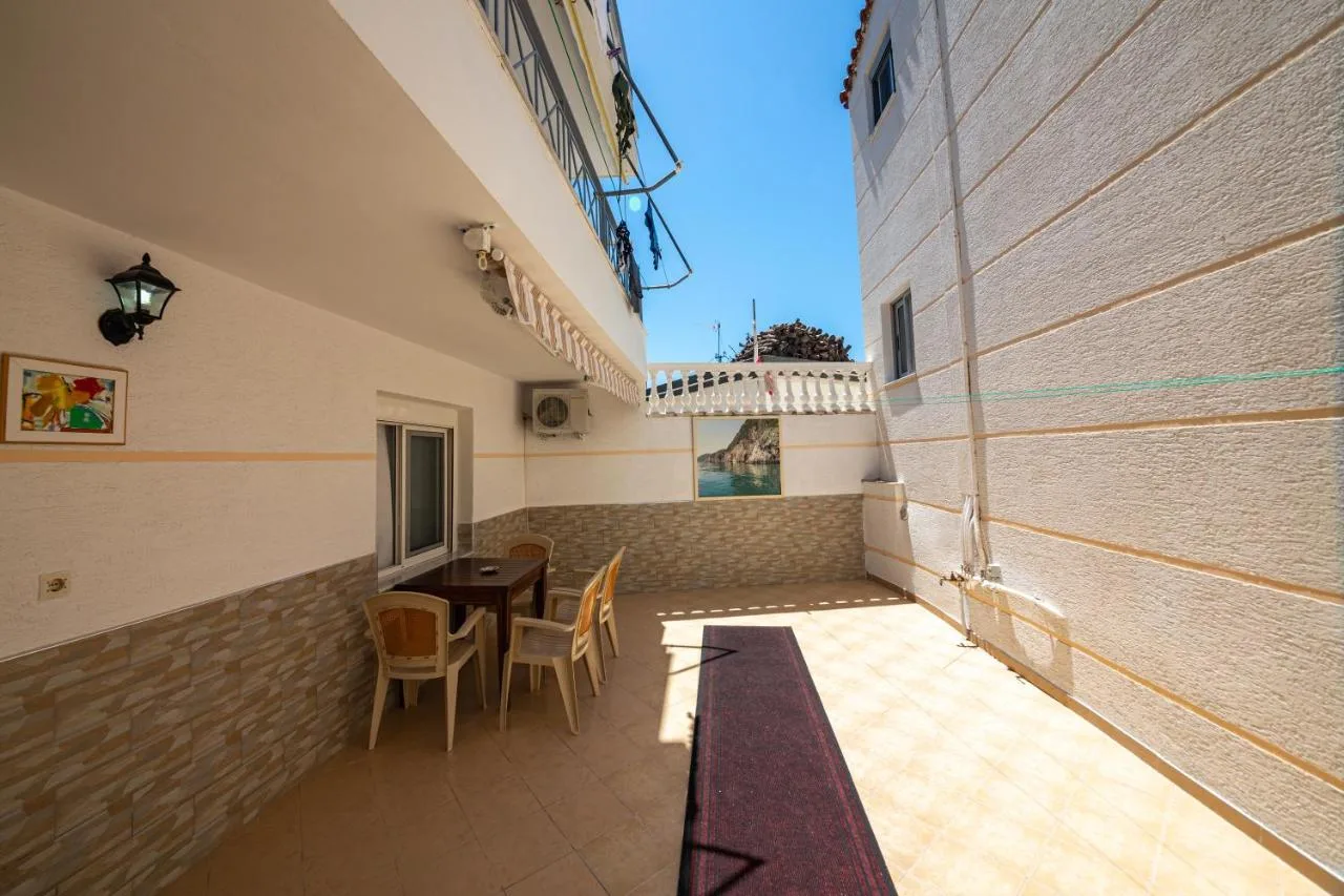 The tiled courtyard in front of the studios, with chairs, a small table and a wall lamp