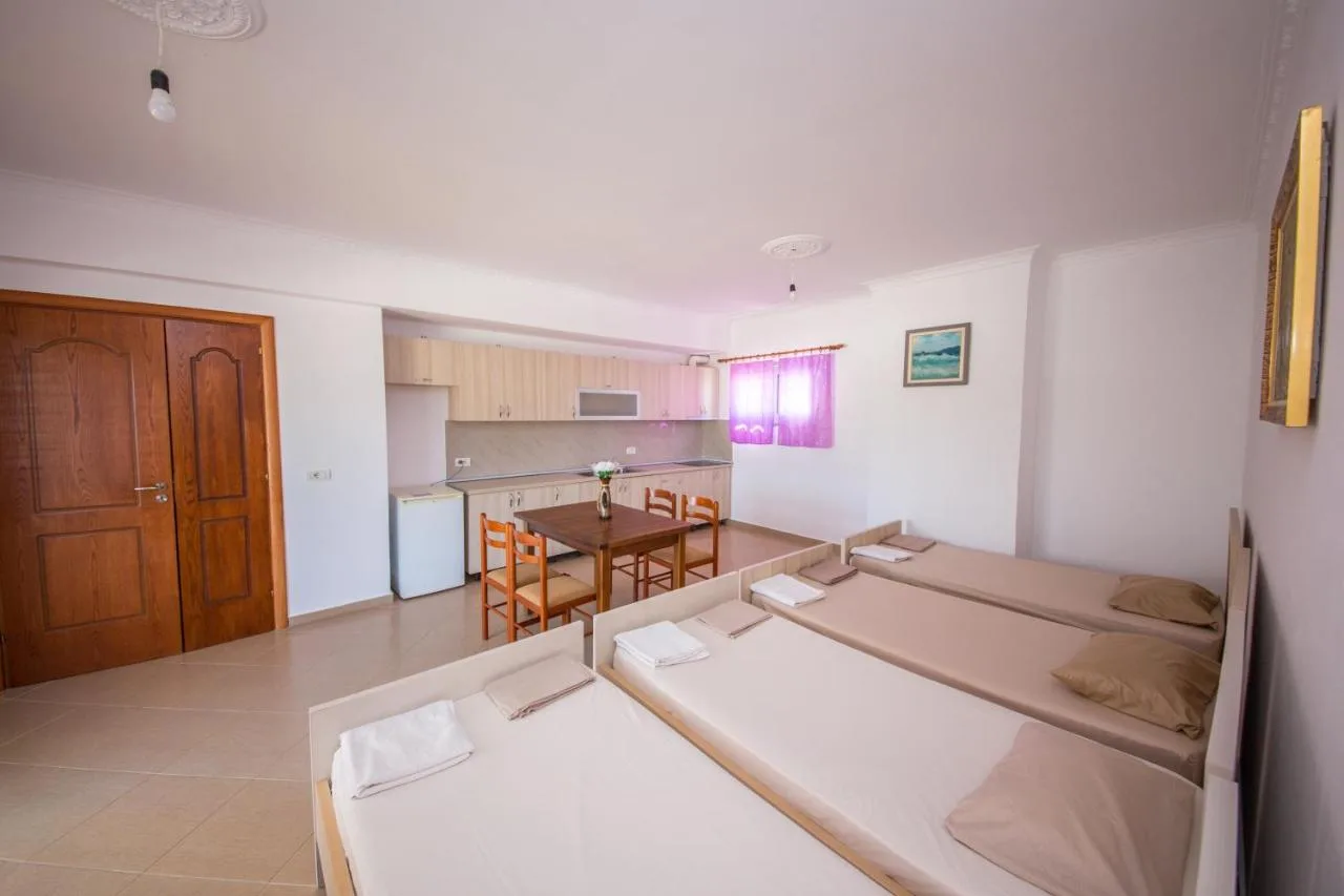The living room from the far end, with a panelled wooden door, sofa beds and the kitchen beyond