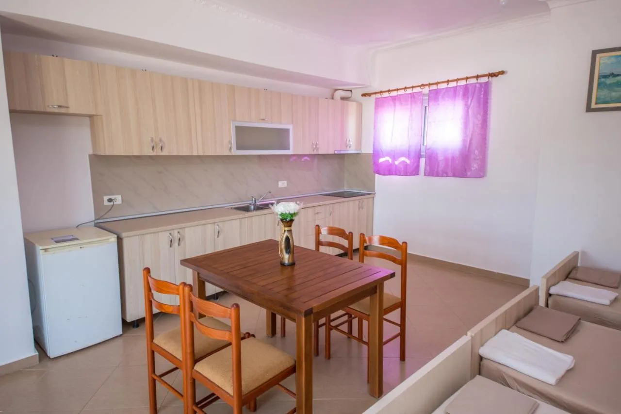The two-bedroom apartment's living room: a kitchen along one wall, a dining table and sofa beds