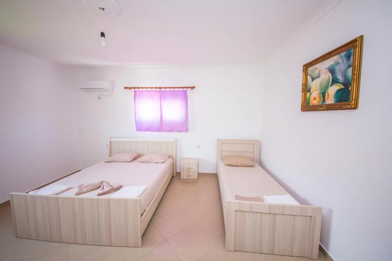 The second bedroom with a double bed, a single bed and a painting over them