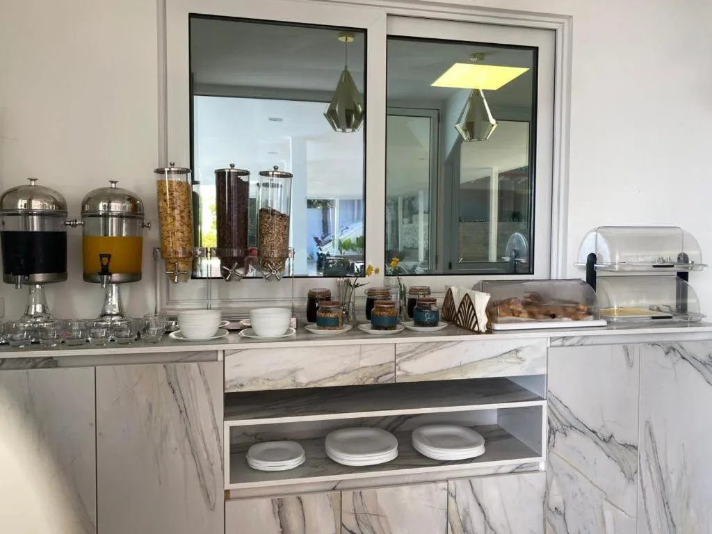 Juice and cereal dispensers and a bread tray on a marble breakfast counter