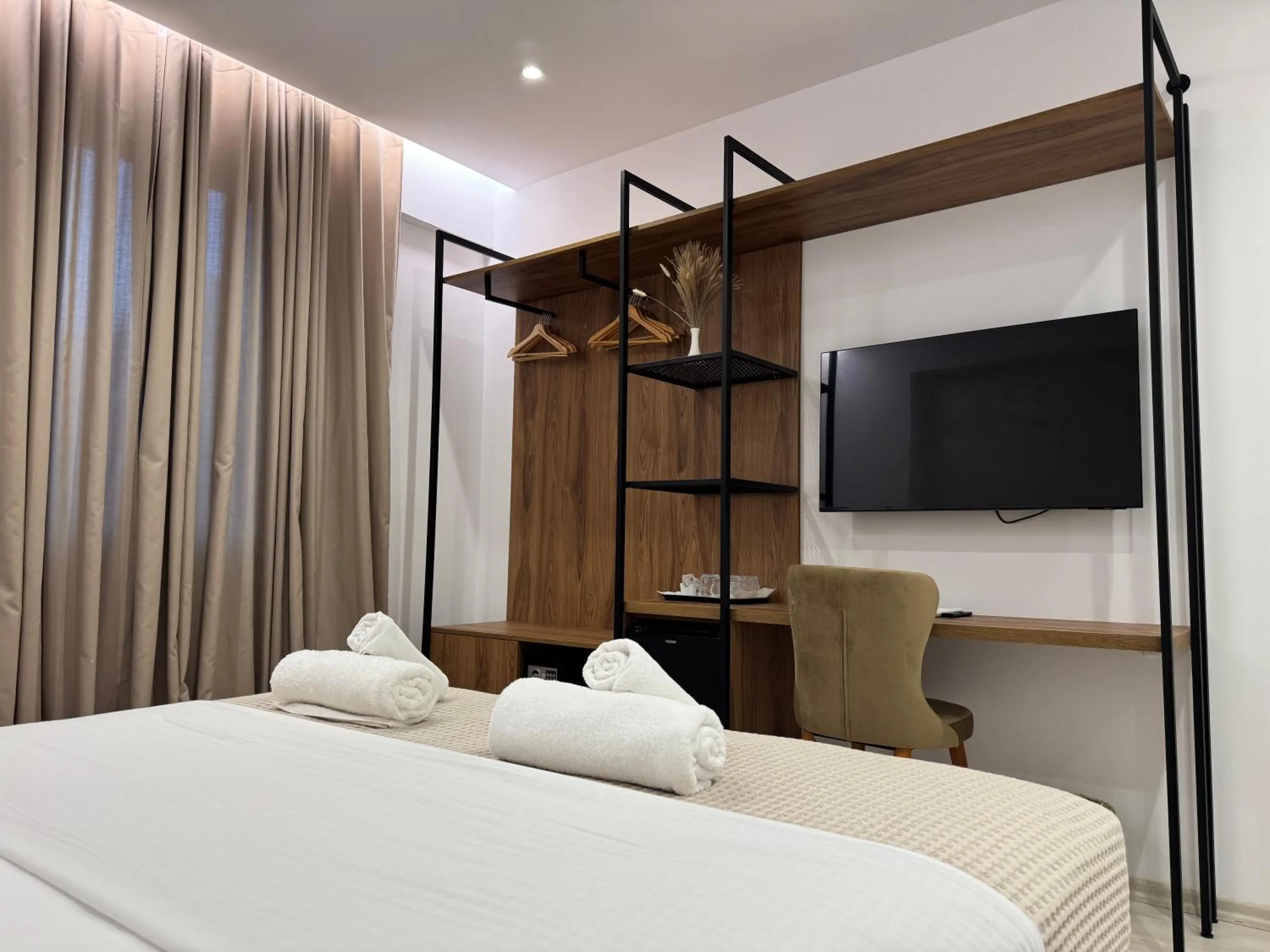 The Deluxe Room's walnut desk and steel hanging rail, the flat-screen TV and the key-card door