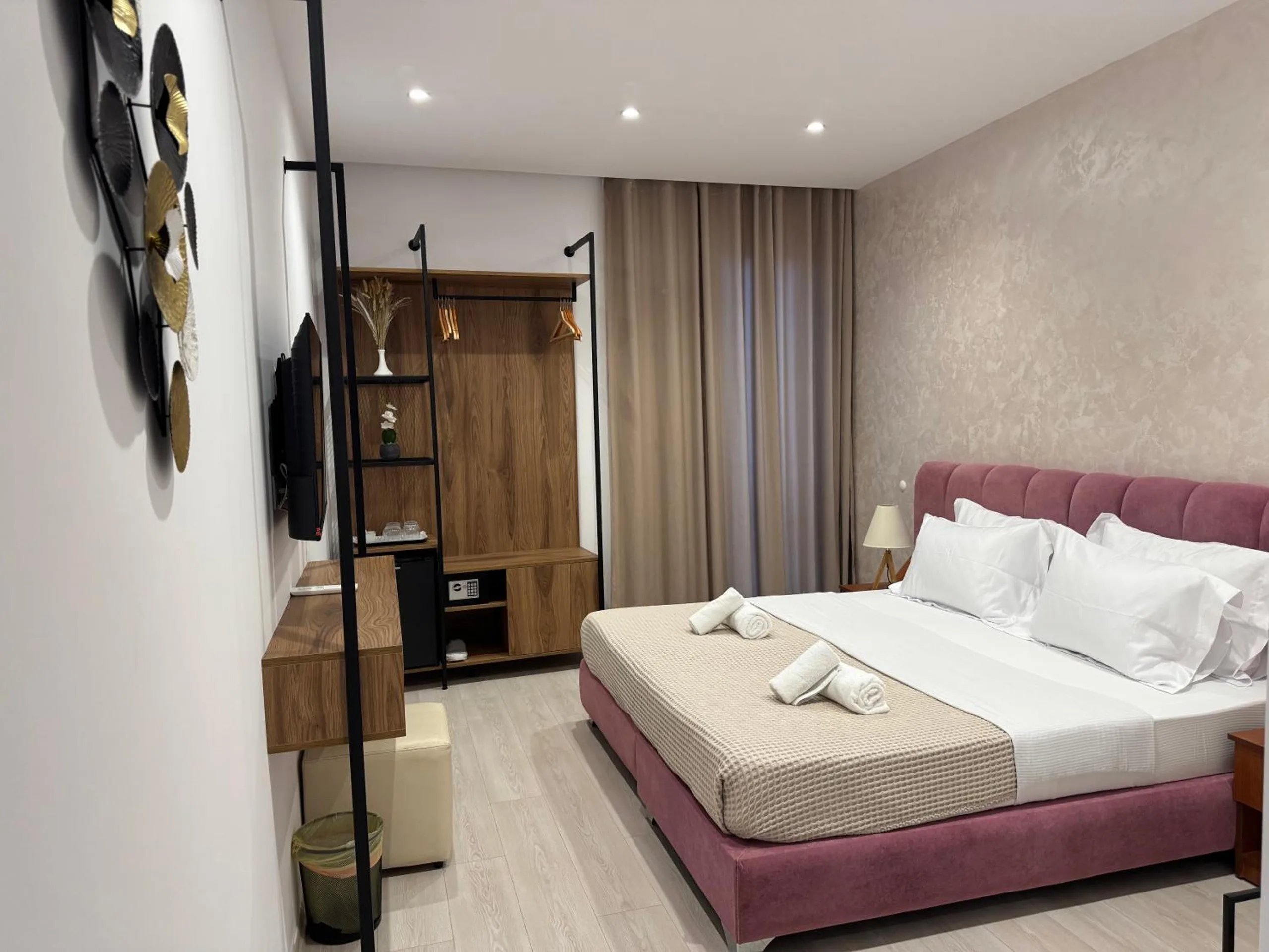 The mountain-view double from the door: the walnut wardrobe and steel rail, the bed and the long curtains