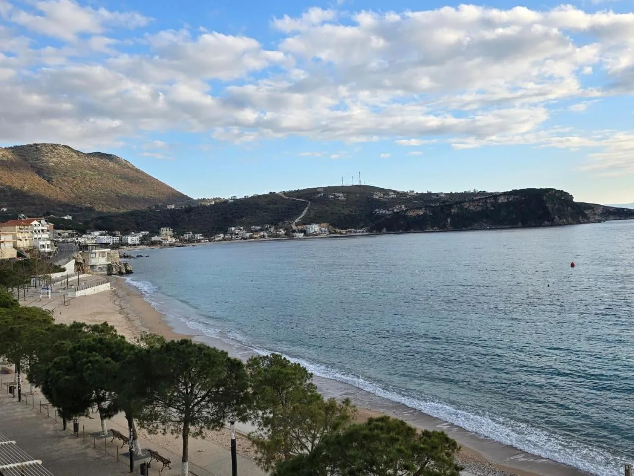 Spile bay from an upper floor of the hotel: the beach, the promenade pines and the town along the shore under the hills