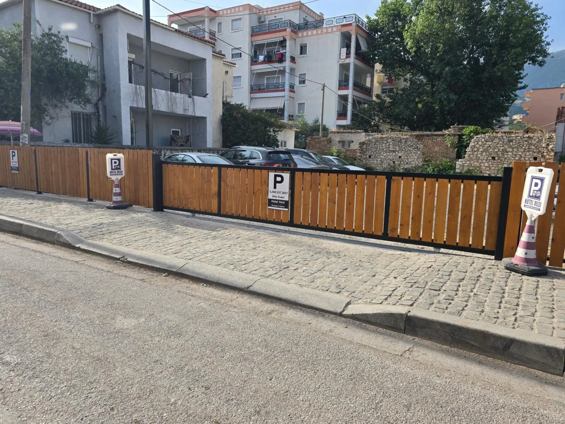 The hotel's fenced car park on a side street, with parking signs on the timber fence