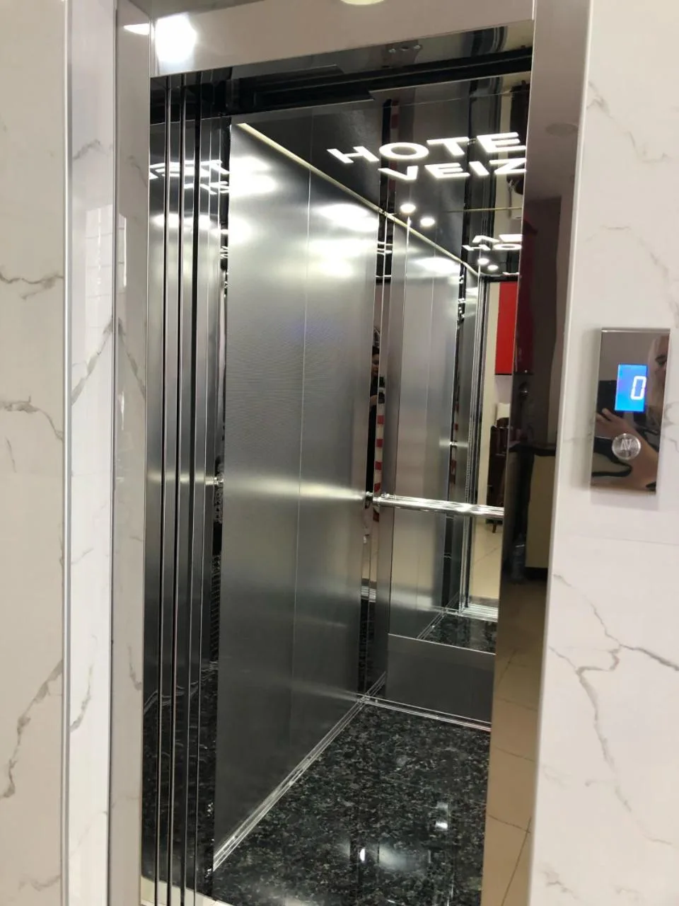 The lift at Hotel Veizi, a mirrored steel car set in white marble