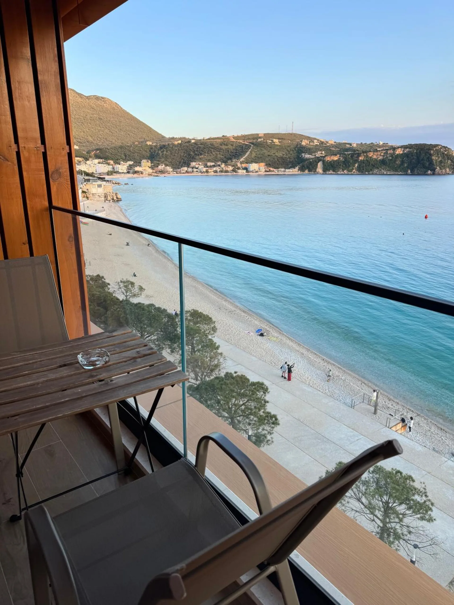 Looking down from a sea-side balcony onto Spile beach and the promenade, the bay curving away to the hills