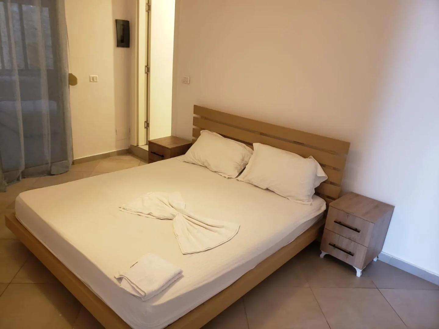 A double bed with a timber headboard and bedside tables