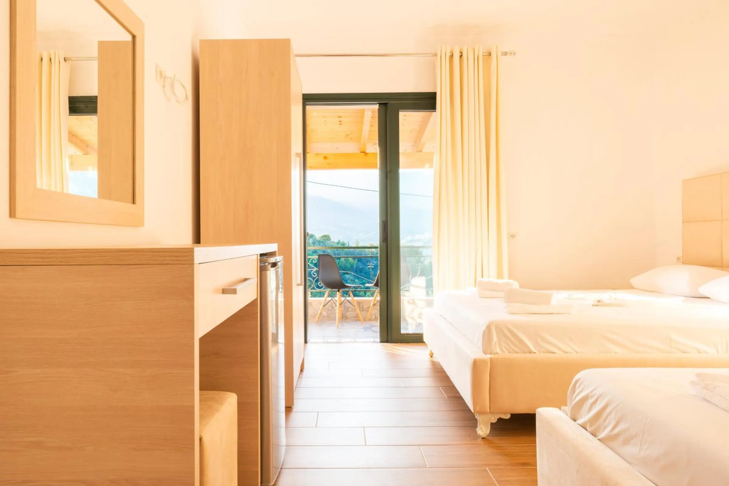 The deluxe triple from the door: an oak dresser and wardrobe, the two beds and the balcony beyond