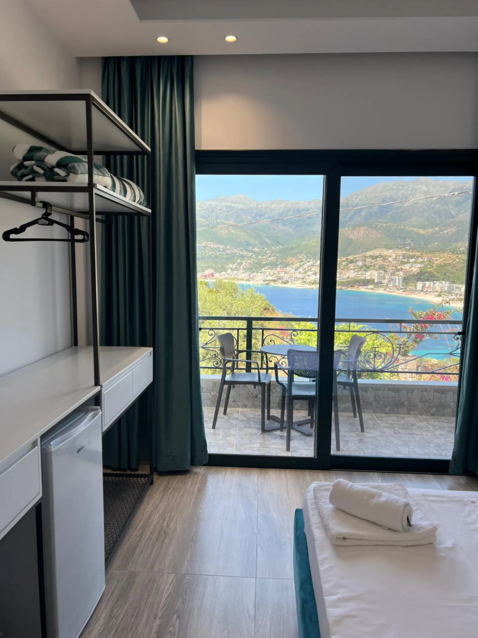 A balcony door framing a table, two chairs and the bay
