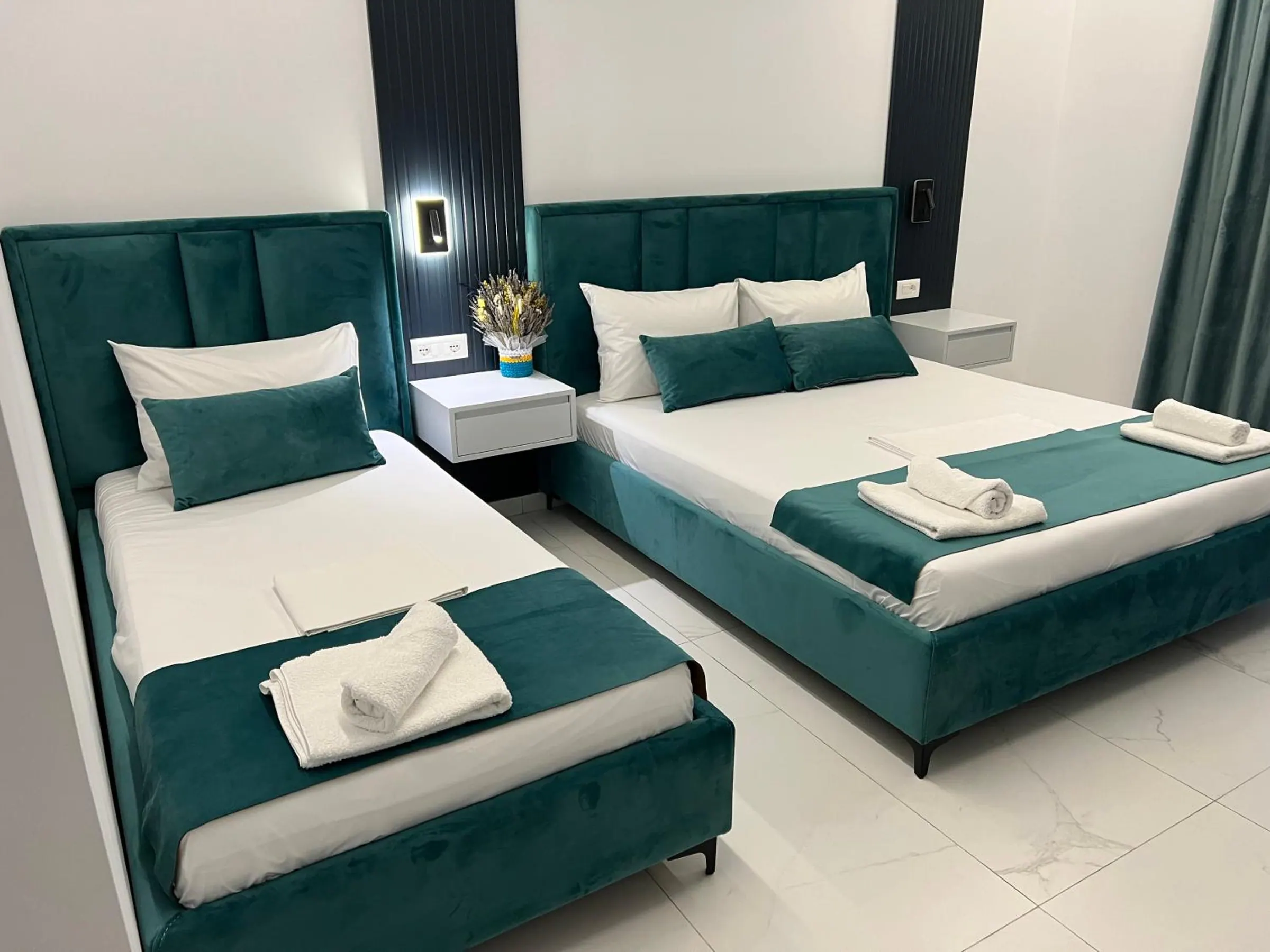 A second view of the teal velvet beds on the marble floor