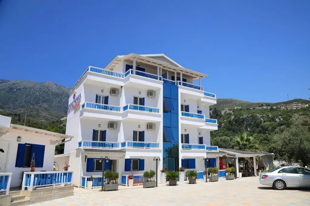 The same white and cobalt front from closer in, the balconies and the blue shutters filling the frame