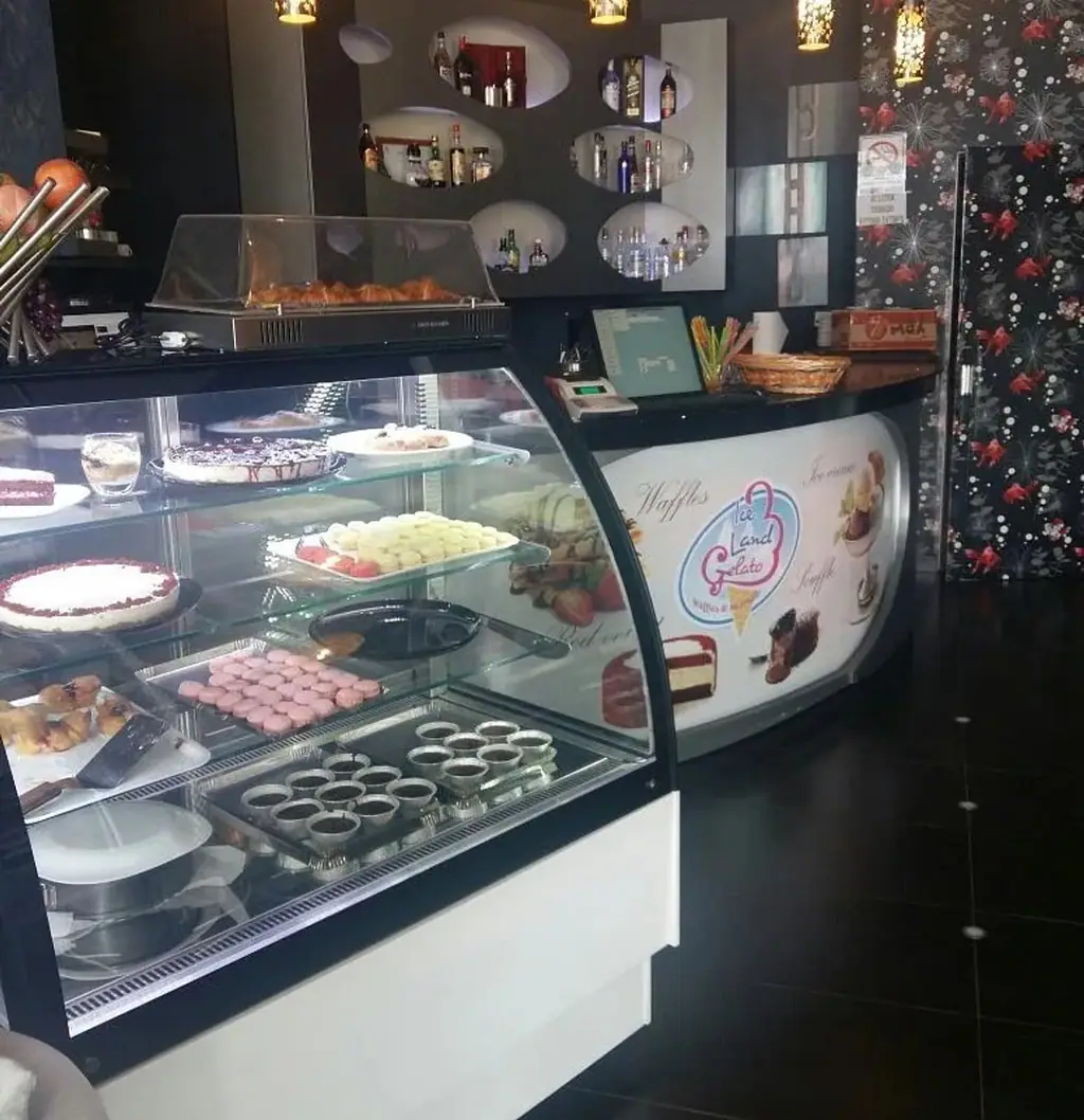 The service counter inside, its curved front printed with the Ice Land Gelato mark and the words Waffles and Ice cream