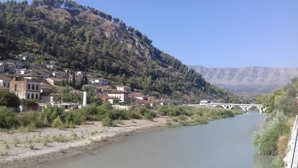 The river below Berat with an arched bridge and the Ottoman town rising on the hillside behind