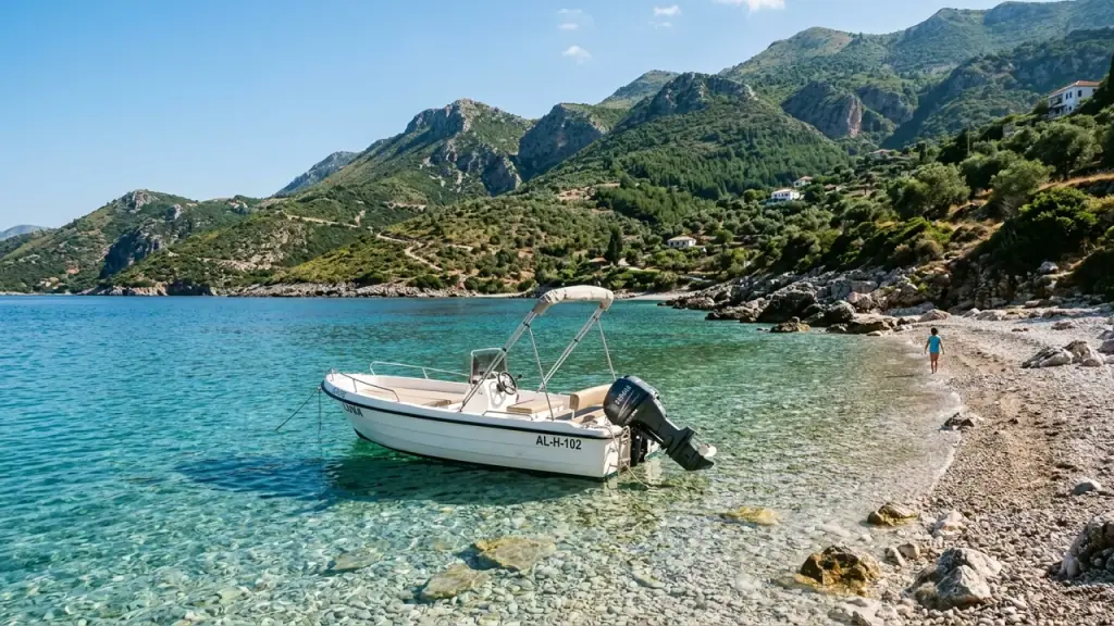 Small rental motorboat anchored in turquoise water in a cove near Himara