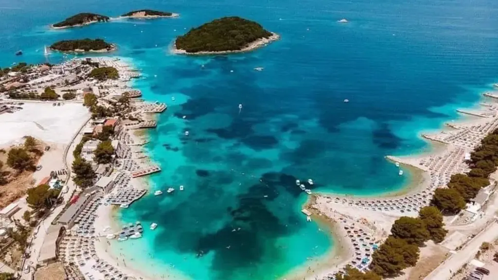 Aerial view of the small wooded Ksamil islets ringed by pale sand and vivid turquoise shallows