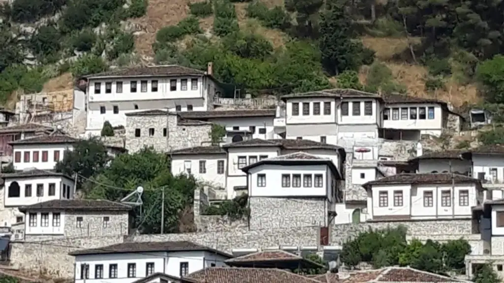 The stacked white Ottoman houses of Berat's Mangalem quarter climbing the hillside, rows of windows facing the valley