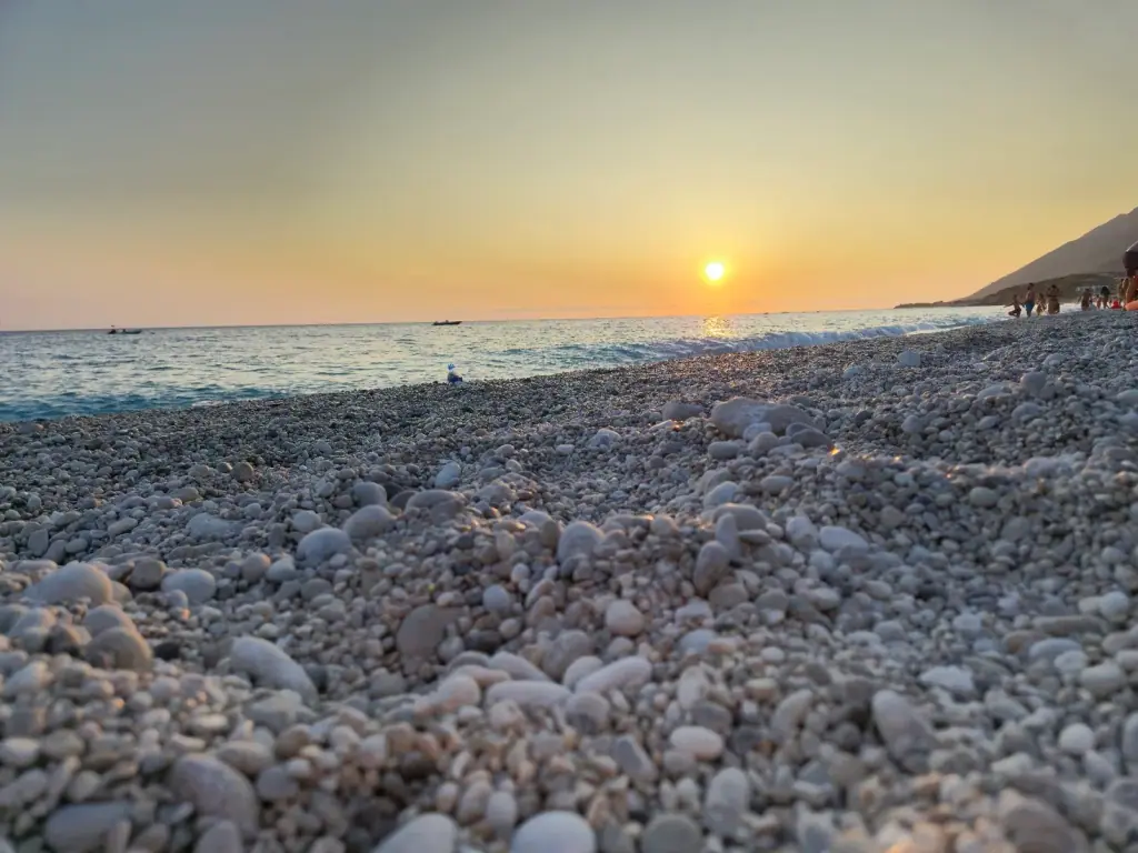 White-pebble shoreline at sunset on Drymades Beach, Dhermi, on the Albanian Riviera