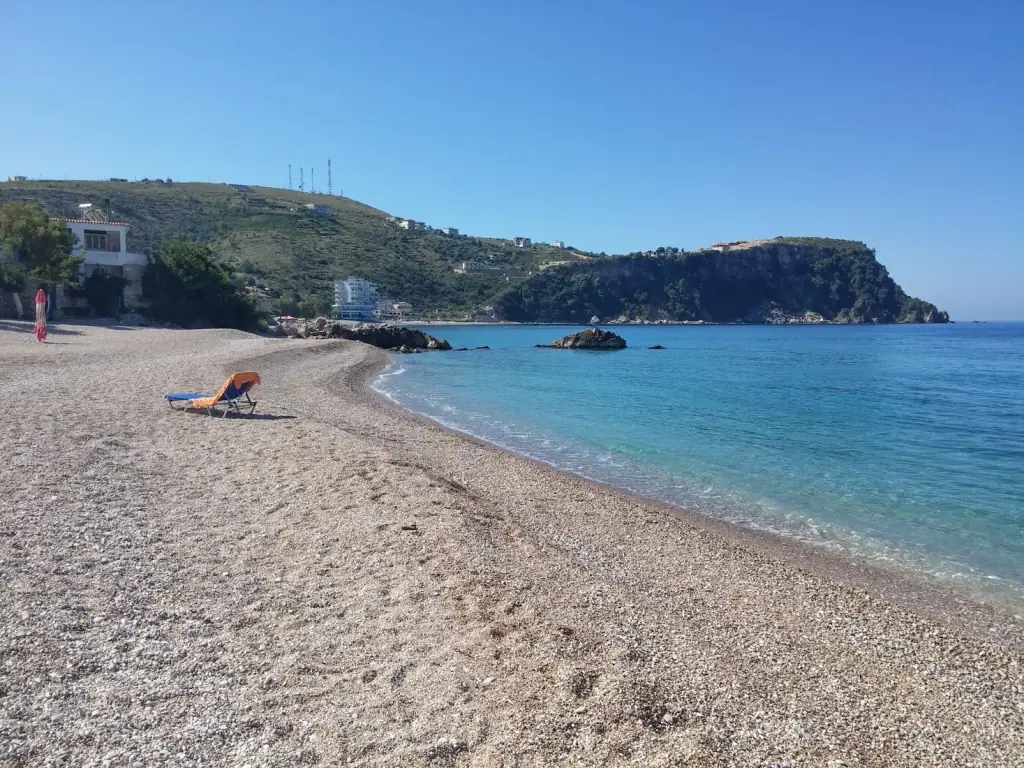 Prinos Beach with clear turquoise water and pebble shoreline along SH8 south of Himara