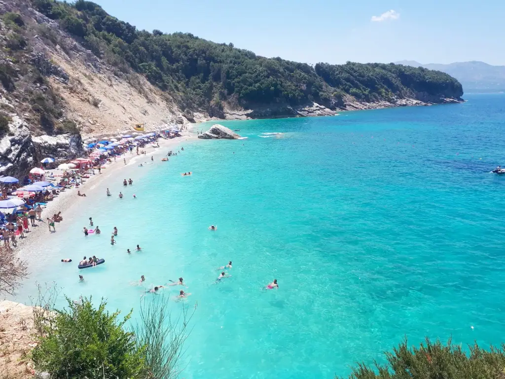The cliff-backed pebble cove and turquoise water of Pulëbardha Beach between Saranda and Ksamil