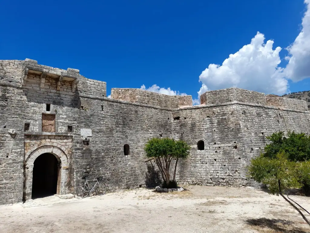 Stone walls and arched gateway of Porto Palermo castle