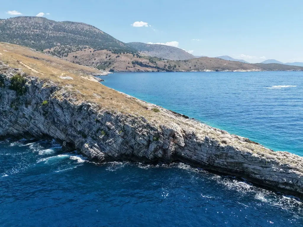 The coastline at Cape of Rigon with cliffs dropping into deep blue water