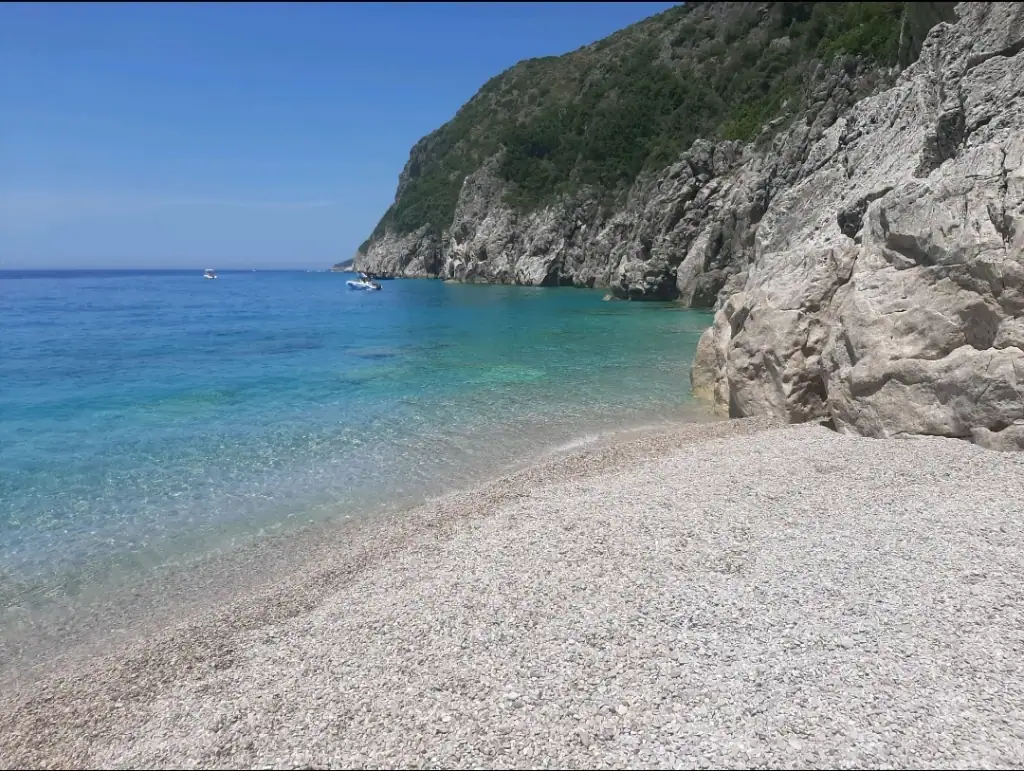 The pebble shore of Couple's Bay below its headland