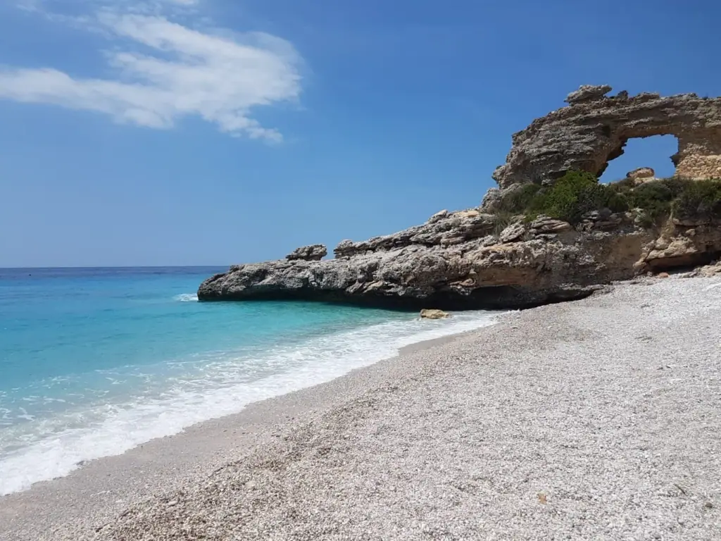 Rock formation at the end of Drymades Beach above clear shallows