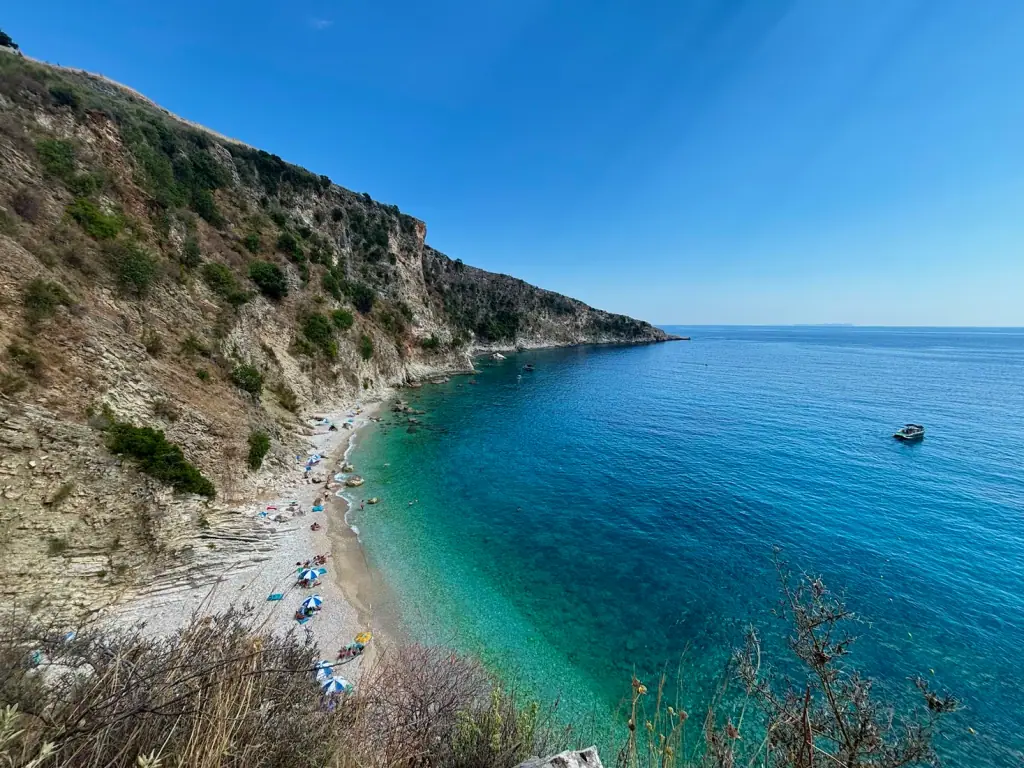 Filikuri's pebble beach from the clifftop with swimmers in the shallows
