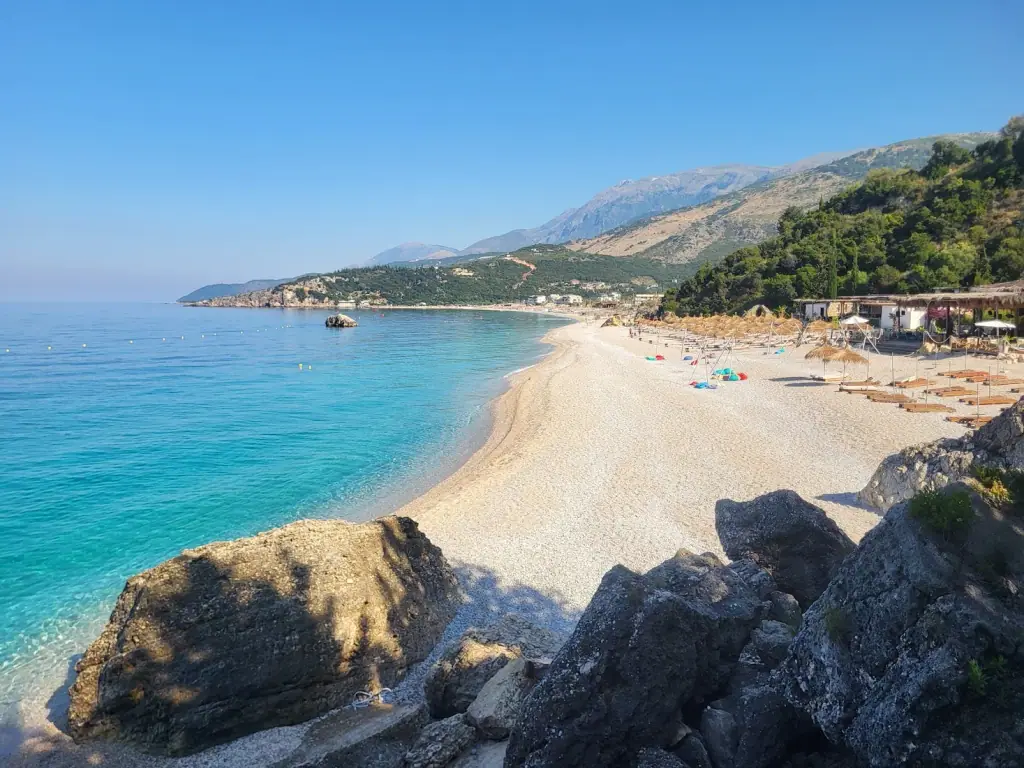 Pebbles and rocks at the Livadhi shoreline with mountains behind