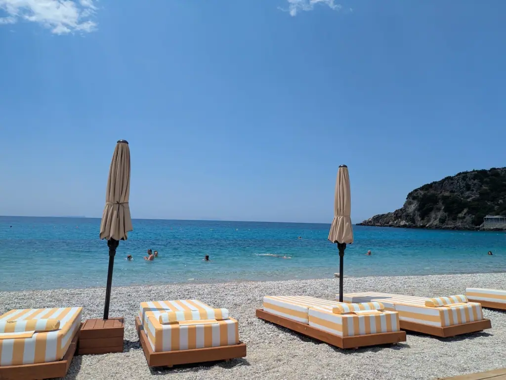 Sunbeds and folded umbrellas on the pebbles at Livadhi