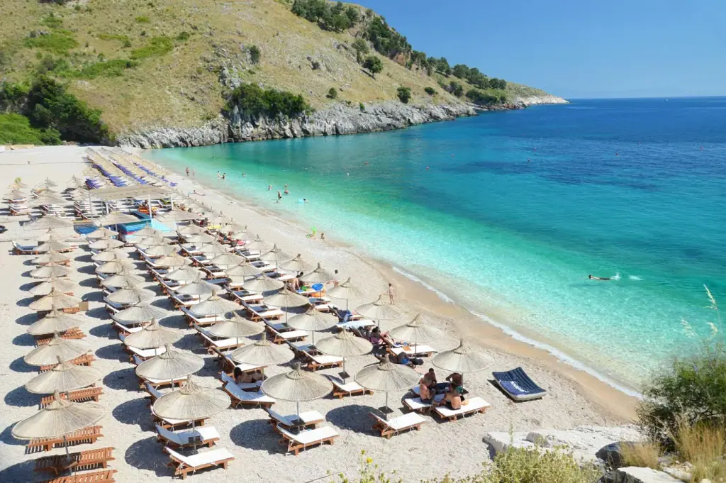 Umbrellas lined along Llamani Beach beside turquoise water