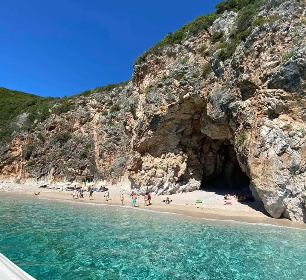 The cave-pocked cliff above Pigeon's Cave with clear green water in the foreground