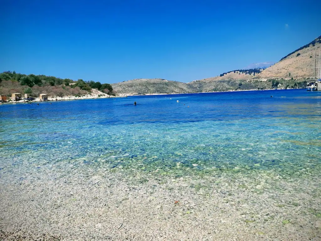 Clear shallow water and the headland across Porto Palermo bay