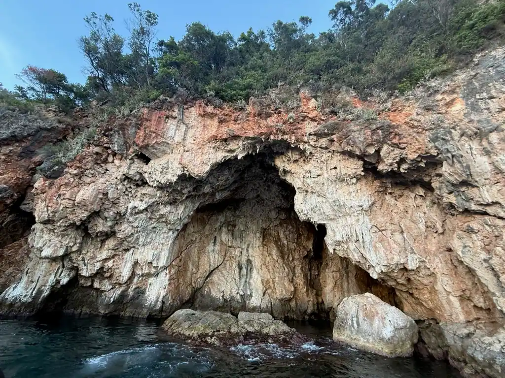 Sea cave arch on the rocky shoreline below Saint Theodore Monastery, near Gjipe