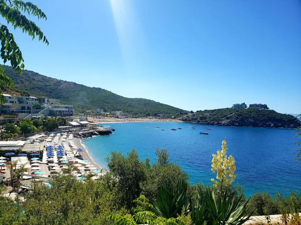 Folie Marine beach club at Jale with rows of umbrellas and sun loungers along the bay and turquoise Ionian water