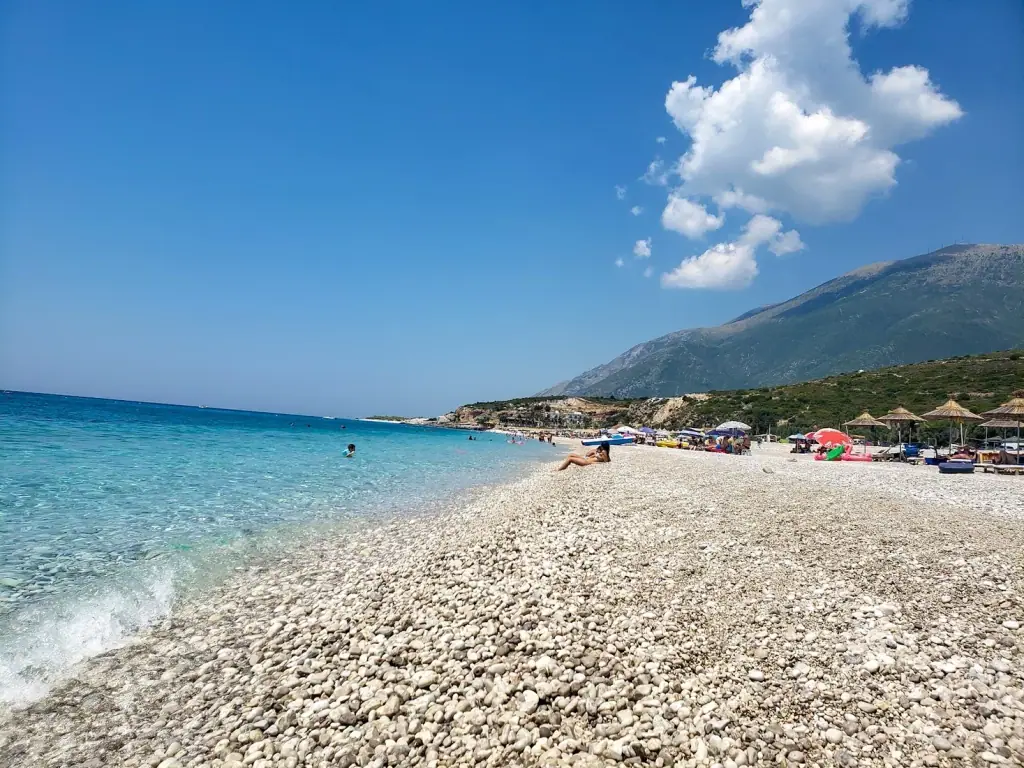 Drymades Beach with white pebbles and blue Ionian waters near Dhermi village