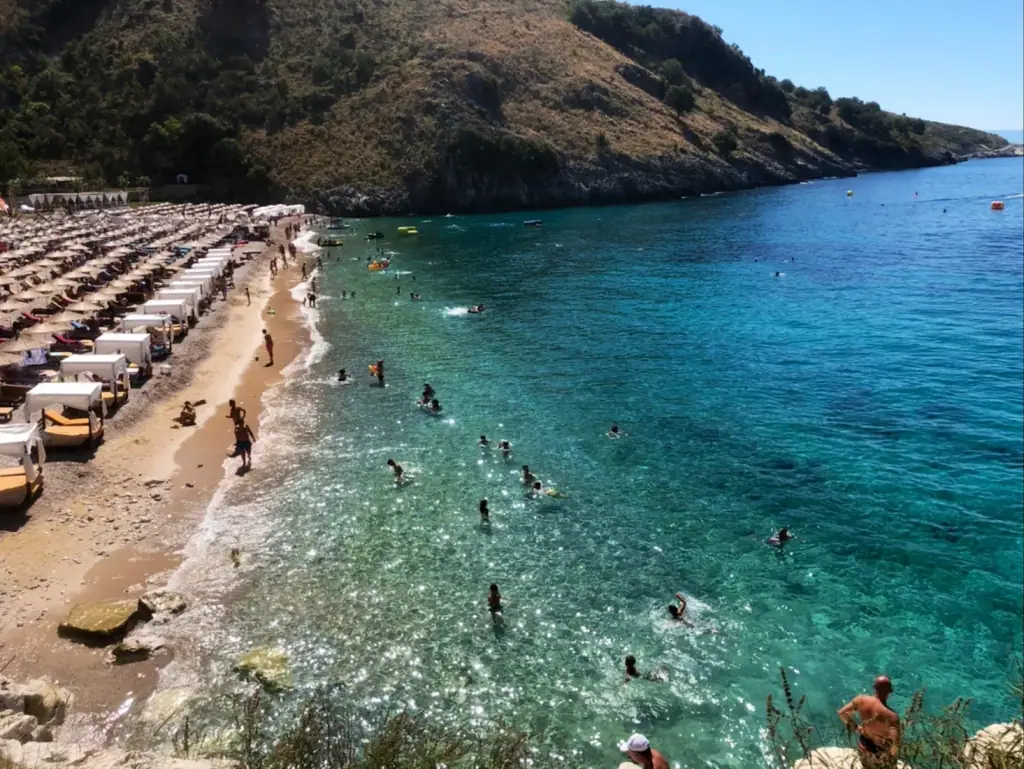 Llamani Beach with deep turquoise water in a secluded bay surrounded by rocky cliffs