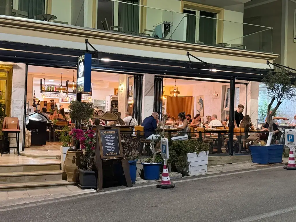 Sea-view terrace with yellow chairs at Tramonto Ristorante in Himara at dusk