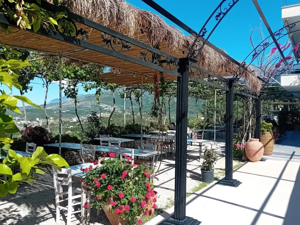 Set outdoor table against a stone wall on the terrace at ELEA Restaurant in Himara