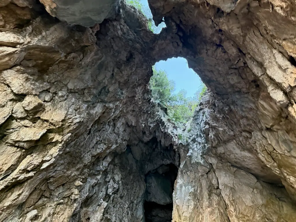 Looking up through the natural rock skylight inside Pirate's Cave near Gjipe on the Albanian Riviera